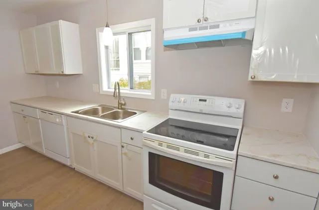 a kitchen with cabinets appliances and a sink