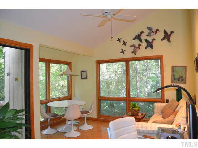 245 Fox Ridge Pittsboro, NC 27312 - Photo 9 of 25 The sunroom has walls of windows overlooking the peaceful woods and creek to the rear of the home.