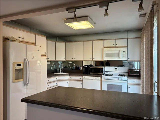 a kitchen with stainless steel appliances a stove a sink a refrigerator and cabinets