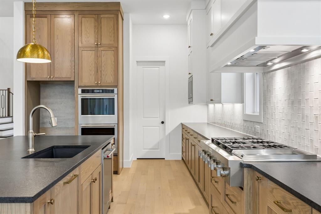 1120 Whirlabout Road Prosper, TX 75078 - Photo 8 of 25 Beautiful two tone cabinetry, gorgeous counter tops and stylish backsplash effortlessly pair with contemporary, top of the line stainless steel appliances to create a dream kitchen for the ages!