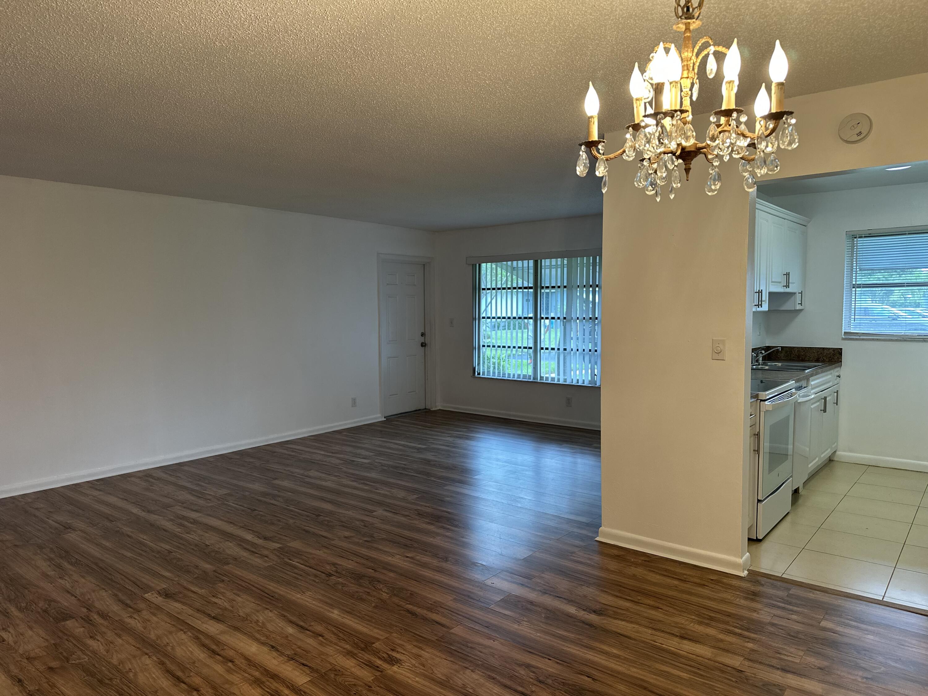 552 High Point Drive, Unit C Delray Beach, FL 33445 - Photo 1 of 13 wooden floor in an empty room with a window