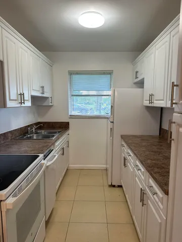 a kitchen with a stove sink and cabinets