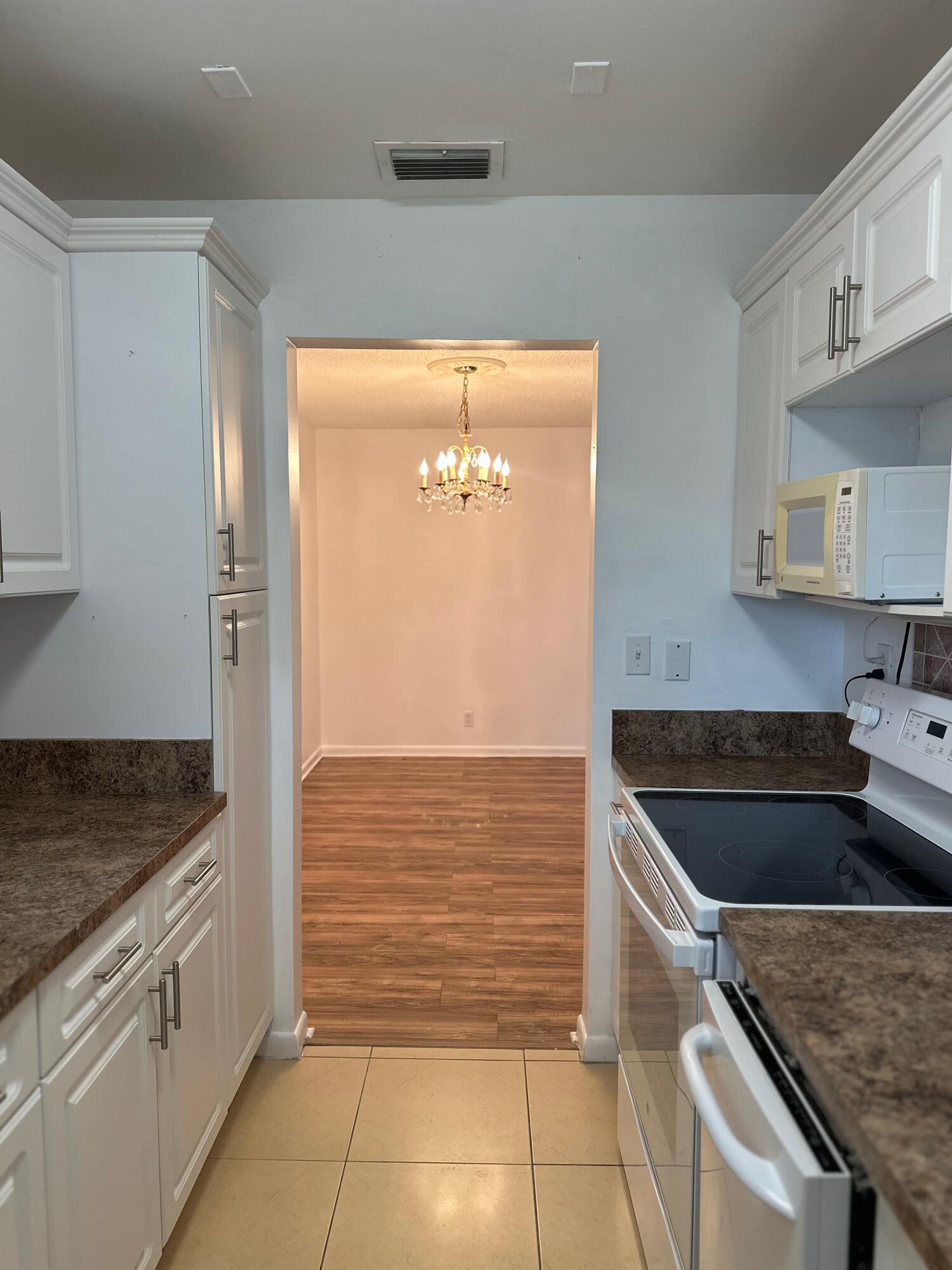 552 High Point Drive, Unit C Delray Beach, FL 33445 - Photo 9 of 13 a kitchen with a sink stove and cabinets
