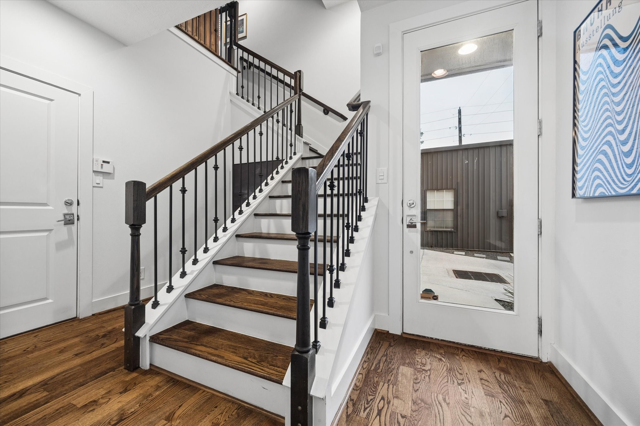 2110 Genesee Street Houston, TX 77006 - Photo 40 of 47 Light-filled entry with soaring ceilings and a statement staircase featuring wood treads and iron balusters.