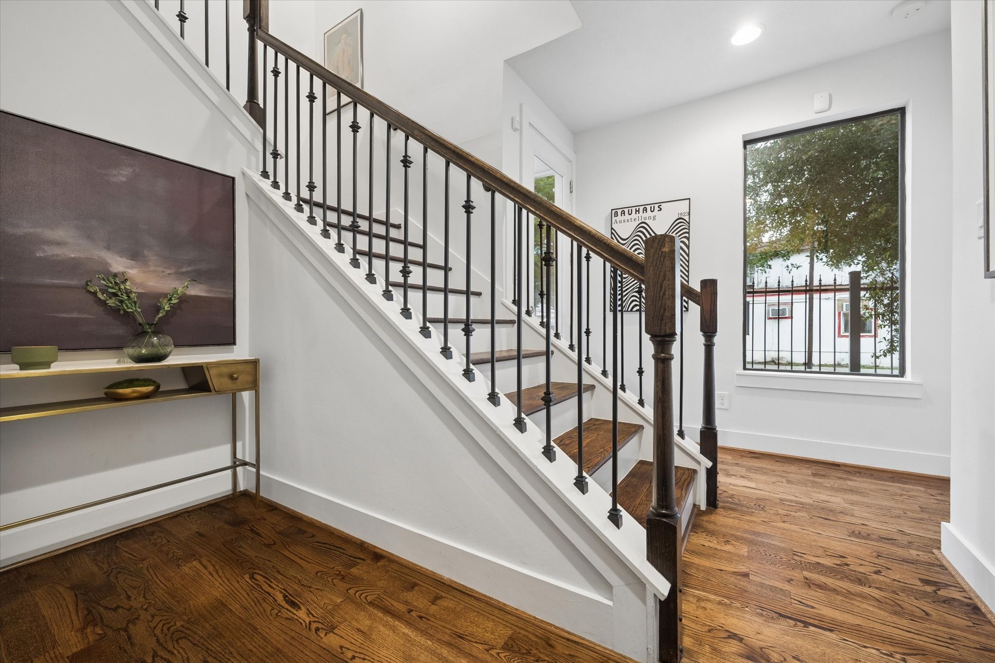 2110 Genesee Street Houston, TX 77006 - Photo 41 of 47 Light-filled entry with soaring ceilings and a statement staircase featuring wood treads and iron balusters.