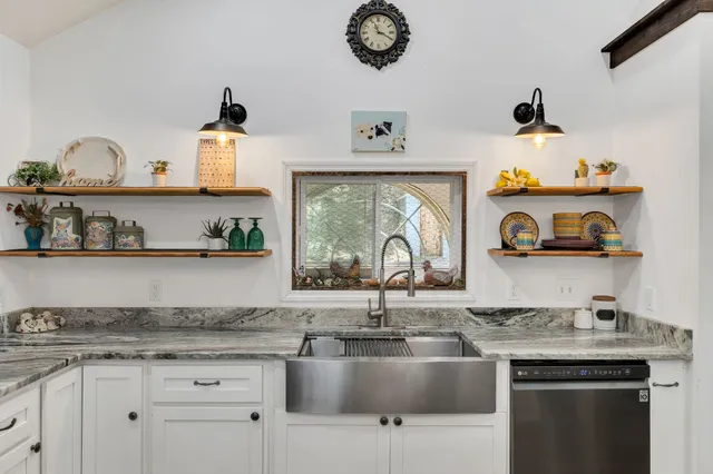 a kitchen with kitchen island a sink a stove and cabinets