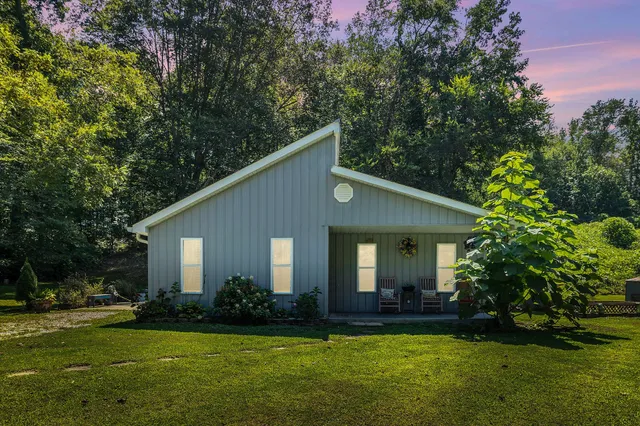 a front view of a house with a garden and yard