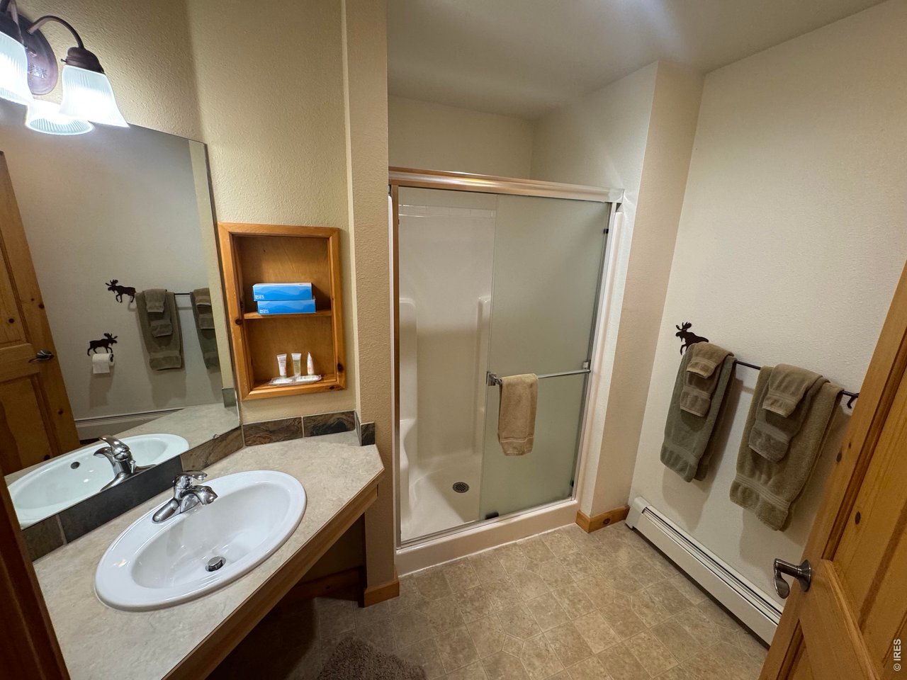 2100 Fall River Road, Unit 4 Estes Park, CO 80517 - Photo 14 of 28 a bathroom with a sink a mirror and shower