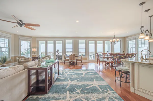 a room with lots of tables a large window and chairs