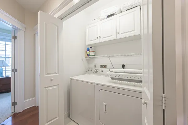 a view of washer and dryer with white cabinets