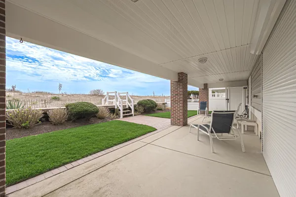 a view of a patio with a table chairs and a yard