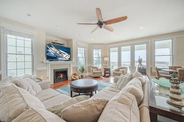 a living room with furniture a fireplace and a floor to ceiling window