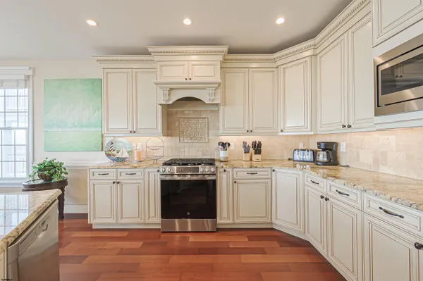 a kitchen with stainless steel appliances granite countertop a stove sink and cabinets