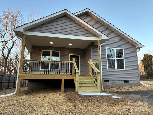 a front view of a house with a deck and furniture