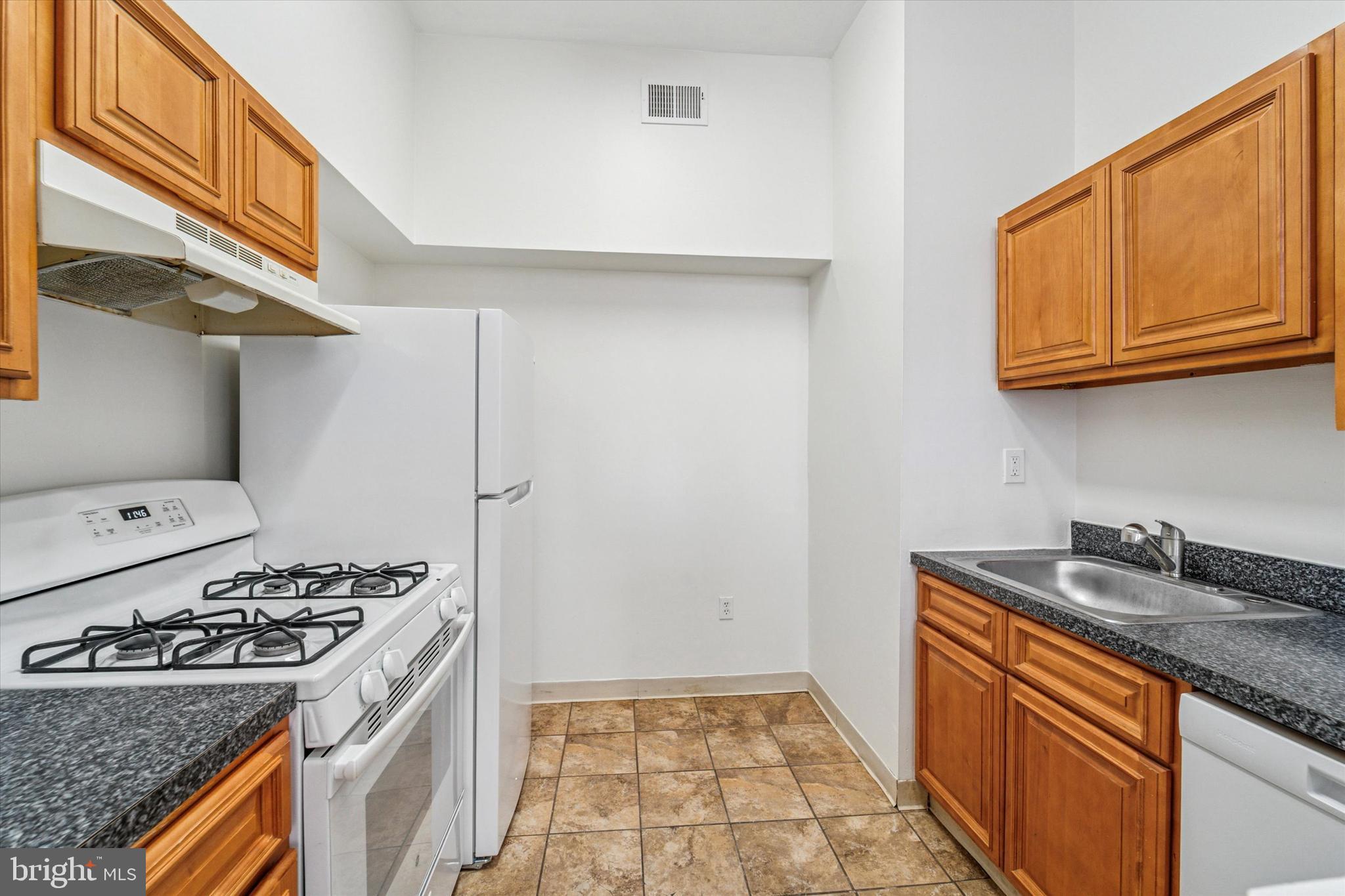 1606 Wallace Street, Unit 101 Philadelphia, PA 19130 - Photo 3 of 10 a kitchen with stainless steel appliances granite countertop a stove a sink and a refrigerator