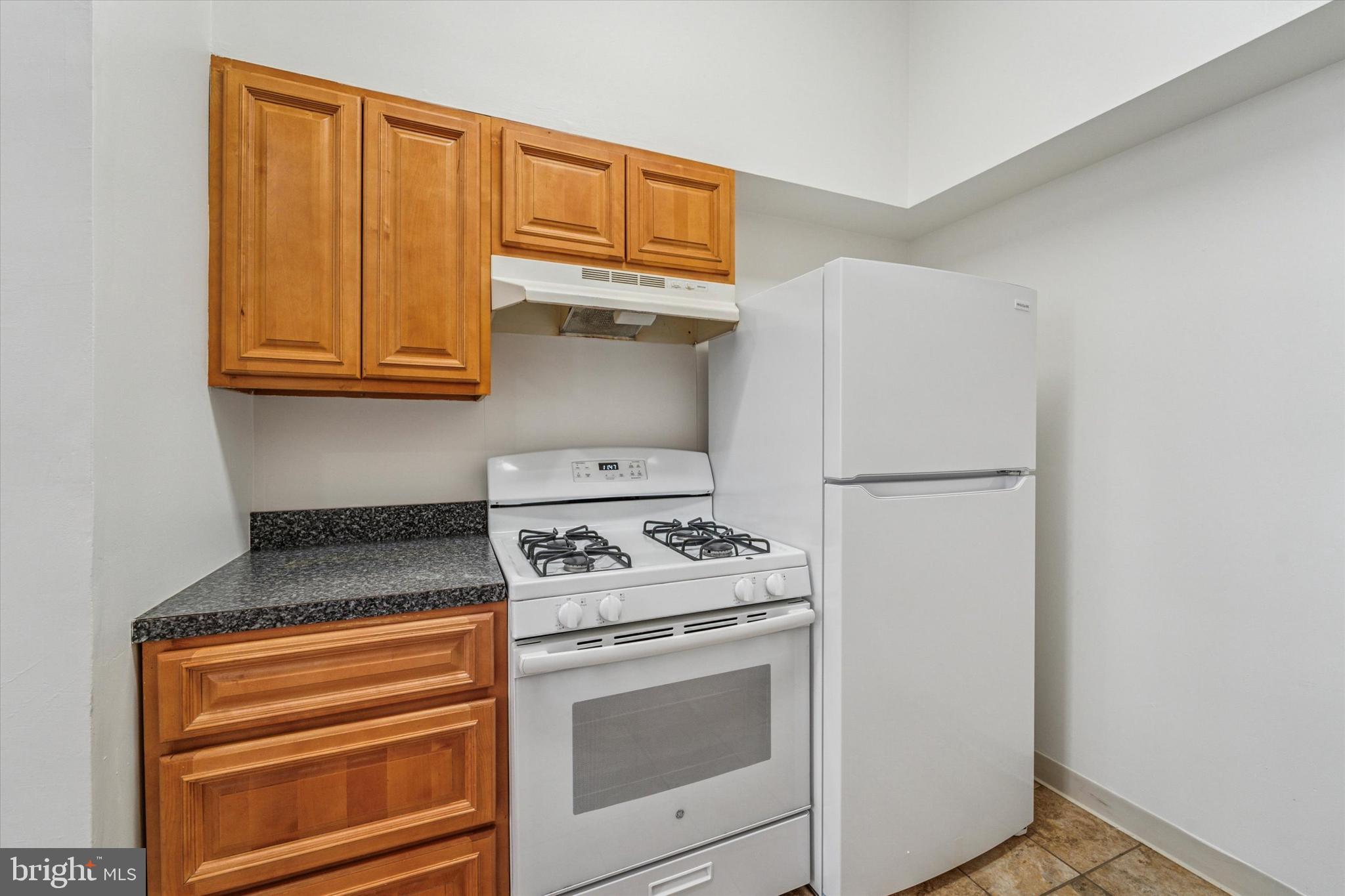 1606 Wallace Street, Unit 101 Philadelphia, PA 19130 - Photo 4 of 10 a kitchen with white cabinets and white appliances