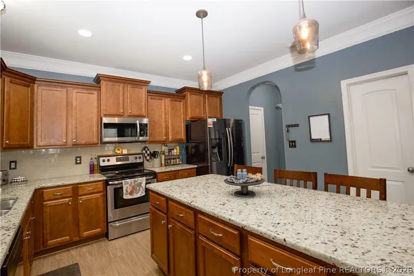 a kitchen with stainless steel appliances granite countertop a sink refrigerator and cabinets