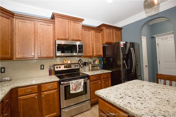a kitchen with granite countertop a refrigerator stove and sink