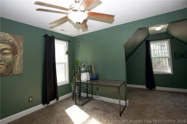 a view of a bedroom with a ceiling fan and a window