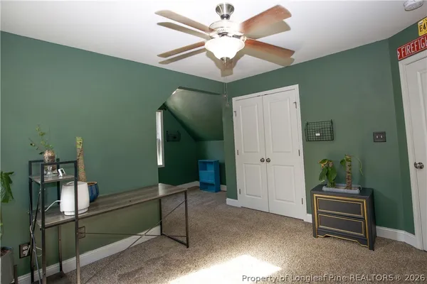 an empty room with a window and a ceiling fan