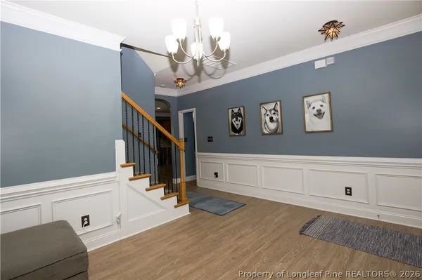 a view of a livingroom with an entryway and wooden floor