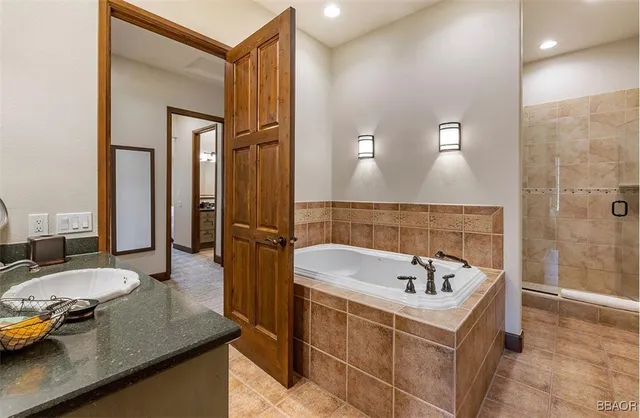 a bathroom with a tub sink and mirror