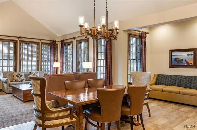a living room with furniture a chandelier and a dining table