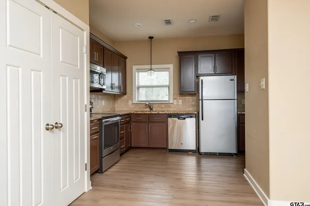 a kitchen with a refrigerator a stove top oven a sink and dishwasher