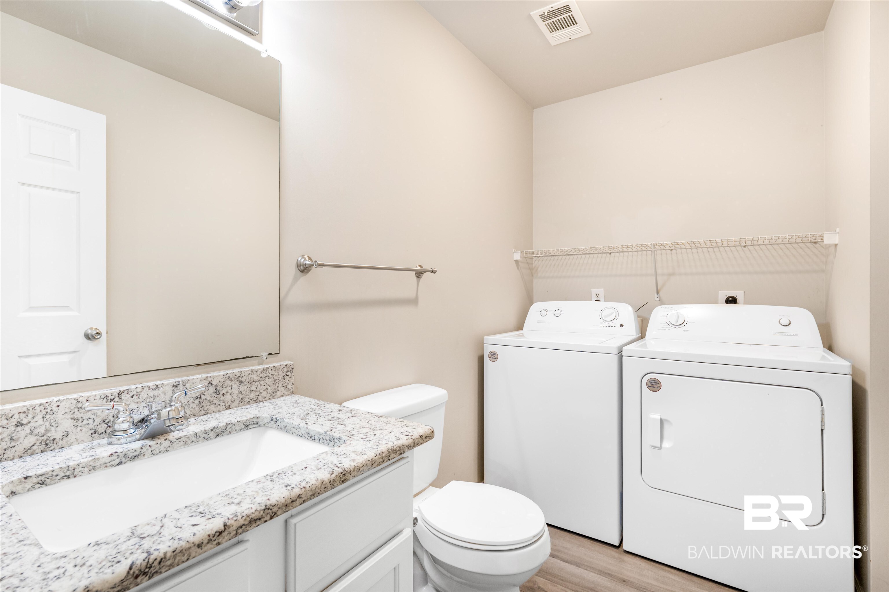 1517 Regency Road, Unit 85 Gulf Shores, AL 36542 - Photo 19 of 32 Bathroom featuring vanity, hardwood / wood-style floors, separate washer and dryer, and toilet
