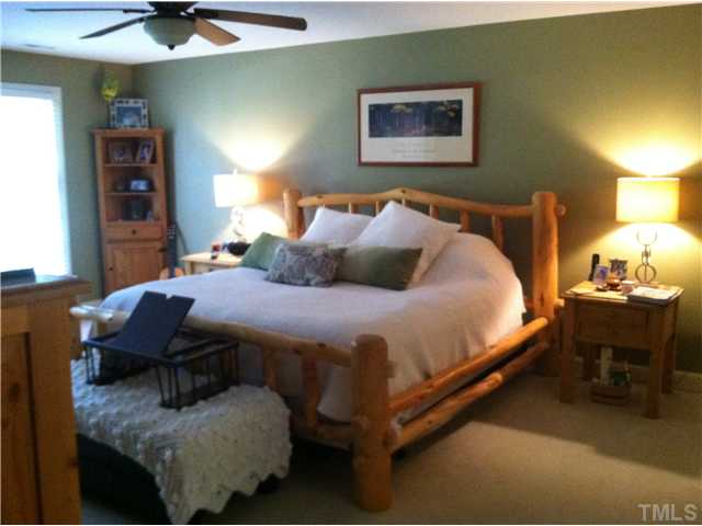 10212 Whitestone Road Raleigh, NC 27615 - Photo 7 of 15 a bedroom with a bed and a chandelier