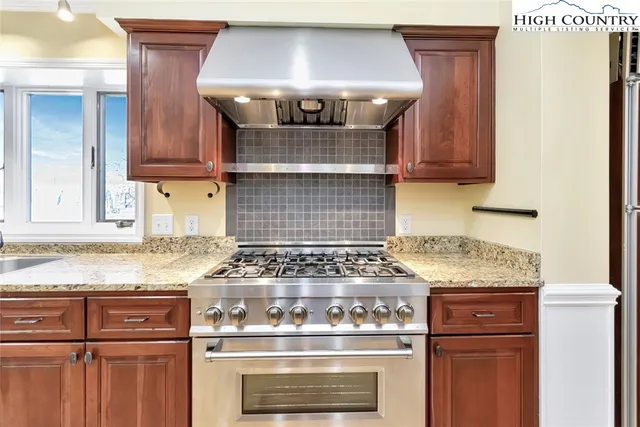 a kitchen with granite countertop a stove and a sink