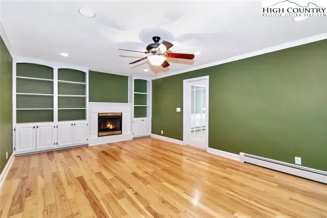 a view of an empty room with a window and fireplace