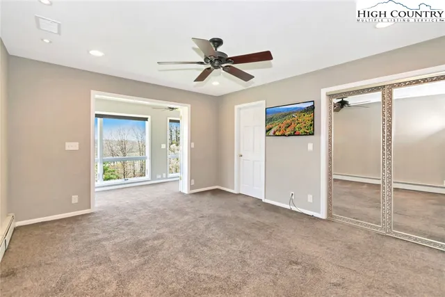 an empty room with windows and fan