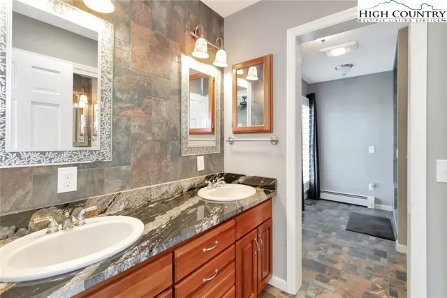 a bathroom with a granite countertop sink and a mirror
