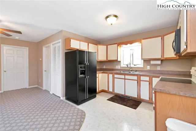 a kitchen with granite countertop a refrigerator and a sink