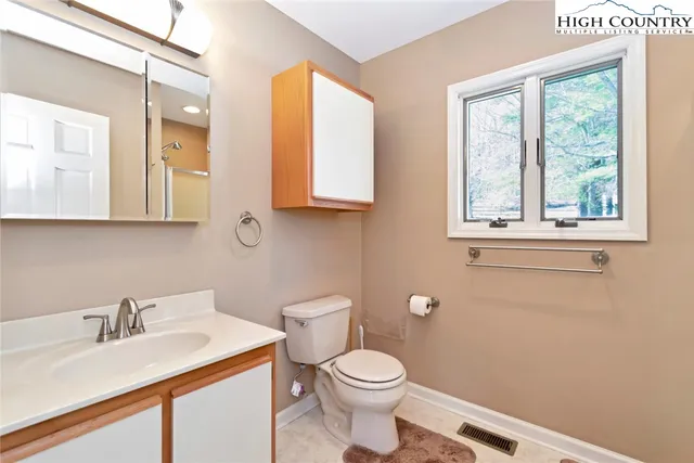 a bathroom with a sink a toilet and a mirror