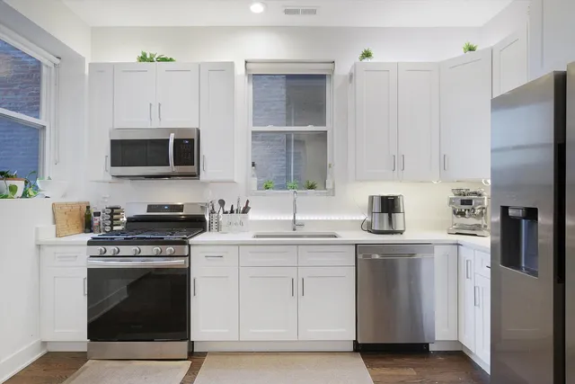 a kitchen with cabinets stainless steel appliances and a sink