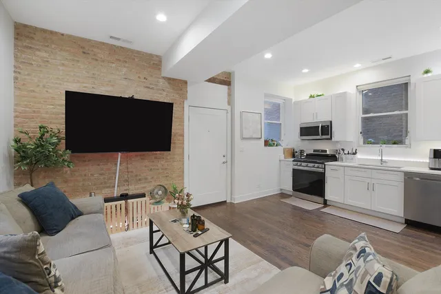 a living room with furniture a flat screen tv and kitchen view
