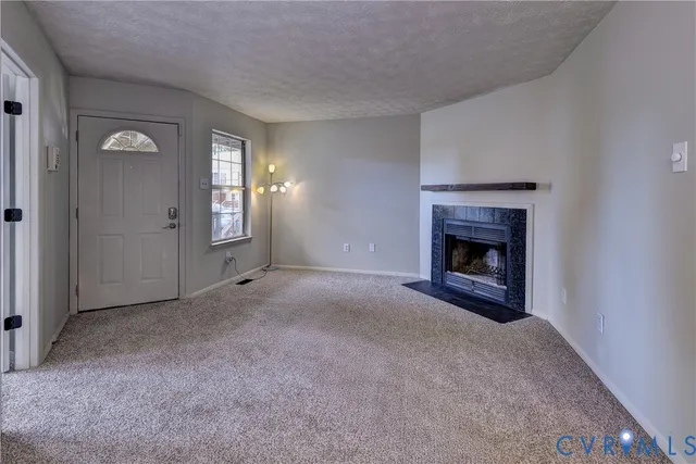 an empty room with windows and fireplace