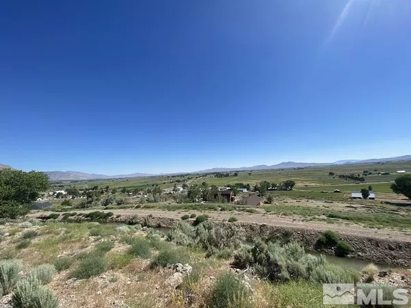 an aerial view of residential houses with outdoor space and lake view