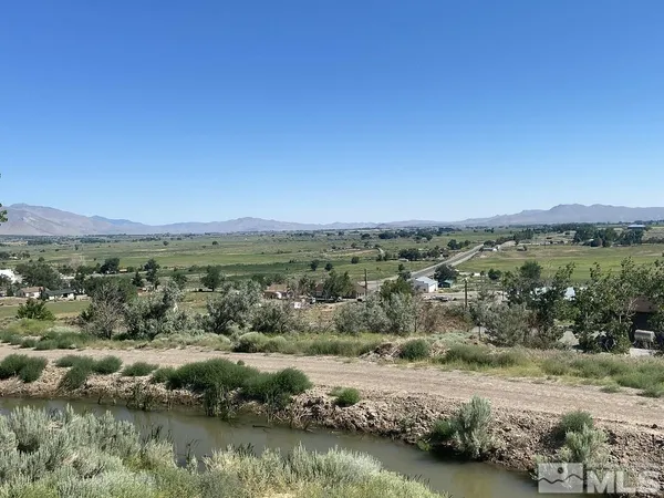 an aerial view of residential houses with outdoor space and lake view
