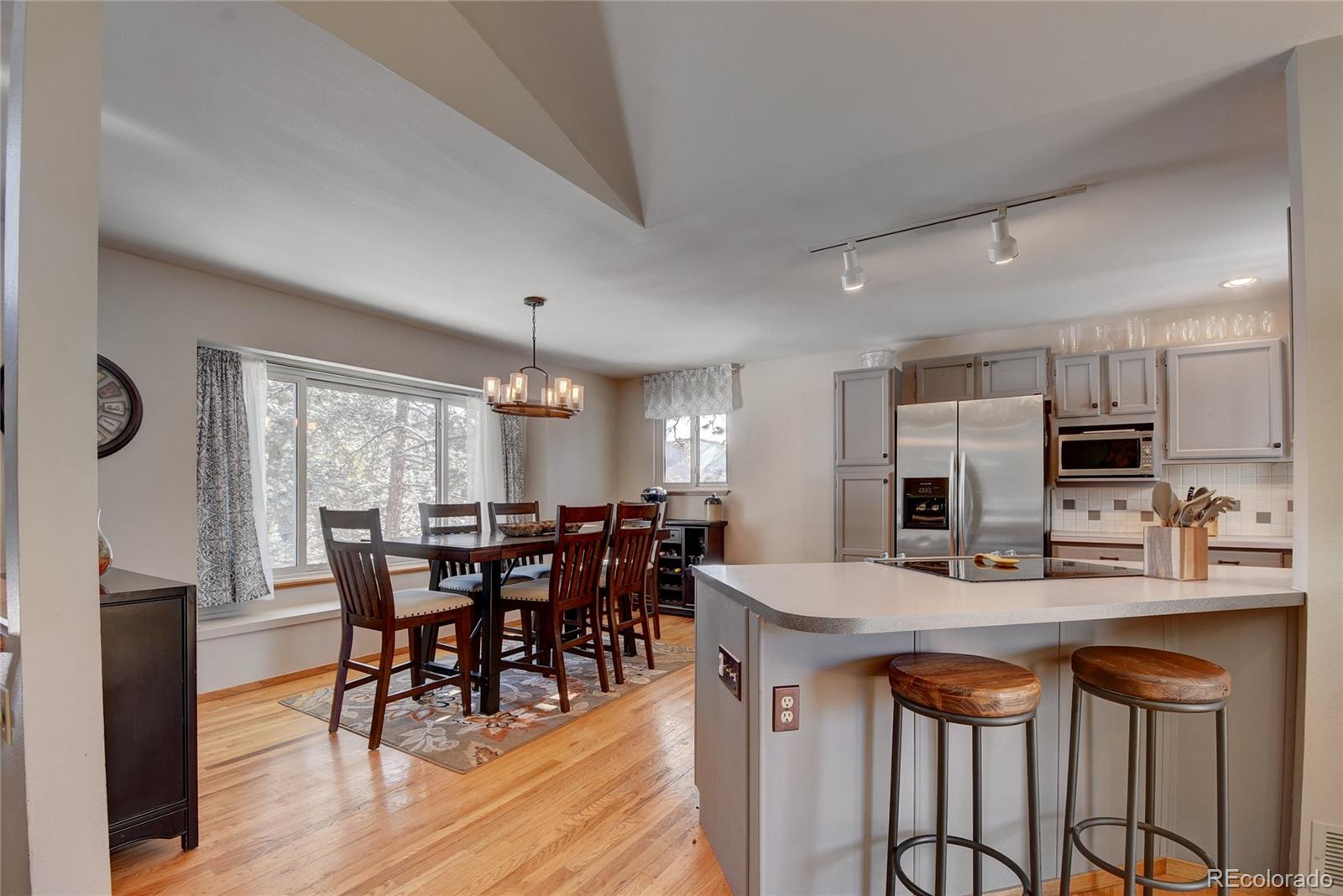 32787 Little Cub Road Evergreen, CO 80439 - Photo 3 of 40 a kitchen with stainless steel appliances granite countertop a dining table chairs and granite counter tops