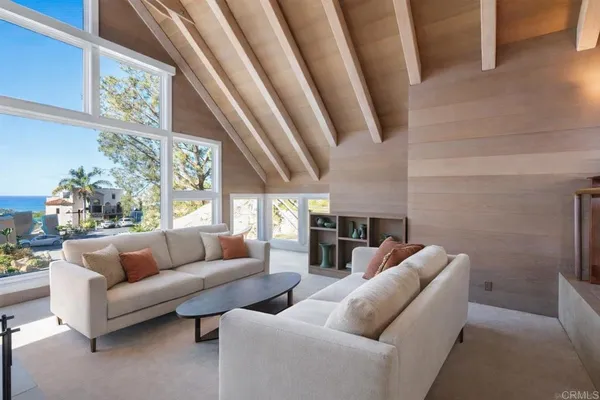 a living room with furniture and a floor to ceiling window