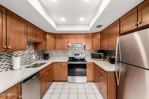 a kitchen with stainless steel appliances granite countertop a refrigerator stove sink and cabinets
