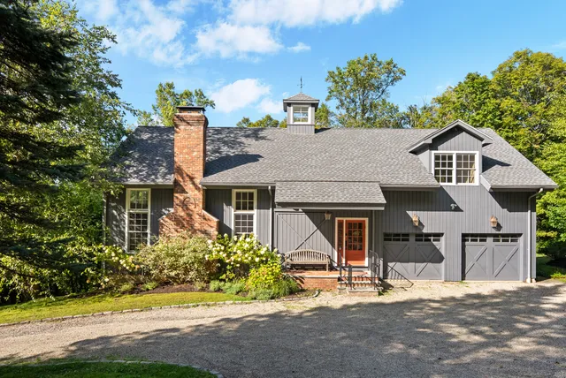 a view of a house with a yard and potted plants
