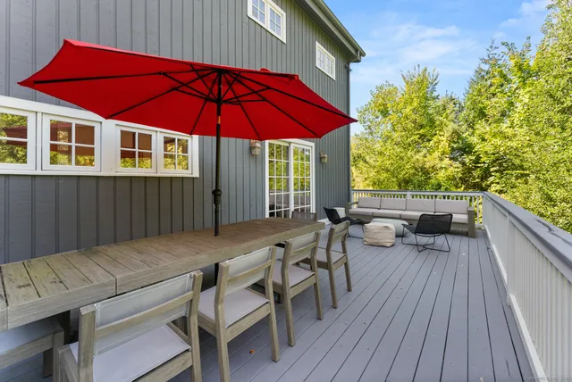 a view of deck with table and chairs under an umbrella