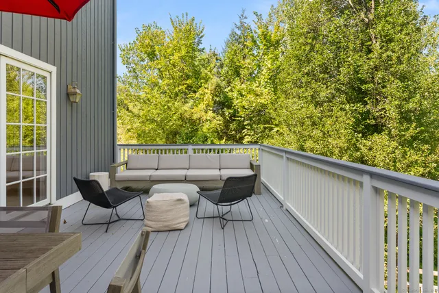 a view of a balcony with chairs and wooden floor