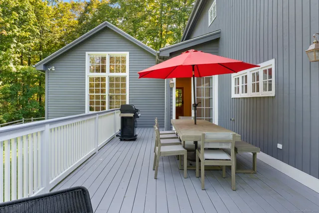a view of a house with a deck and furniture