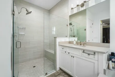 a bathroom with a shower sink and mirror
