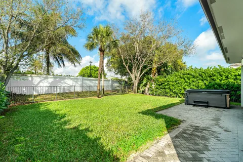 a view of a backyard with potted plants and large trees